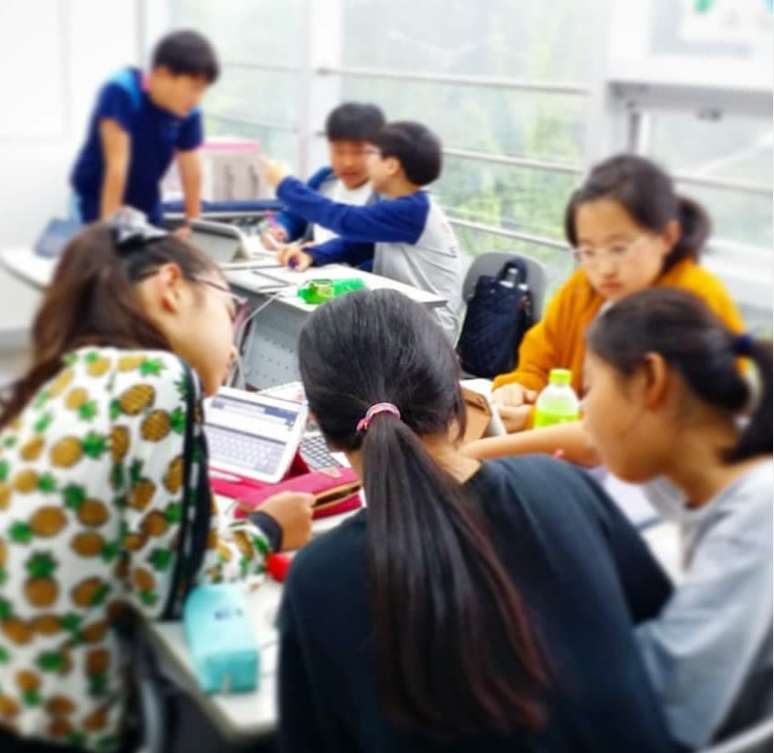 Korean hagwon students working in a group project in classroom