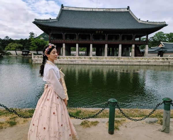 woman in Korean traditional hanbok in front of a pagoda