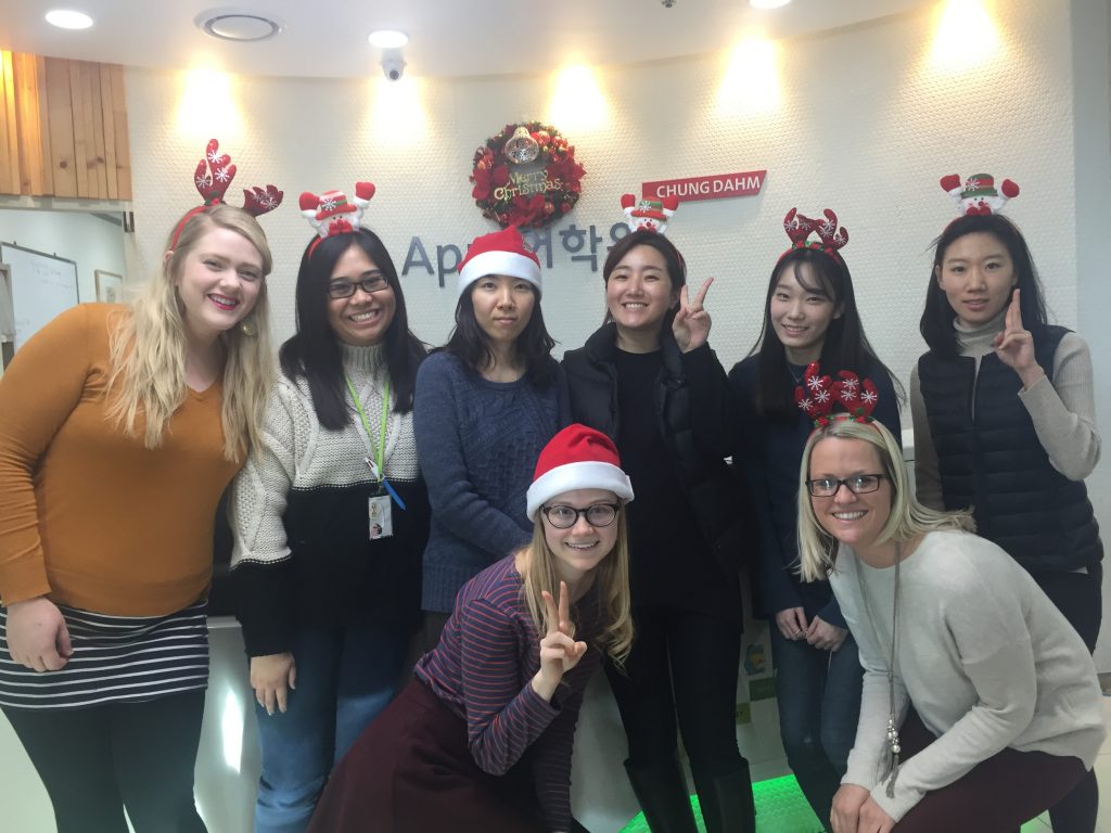 English language teachers posing in front at their school with Christmas hats