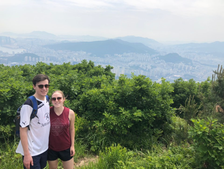 Couple posing with a view off a cliff in the background in Korea