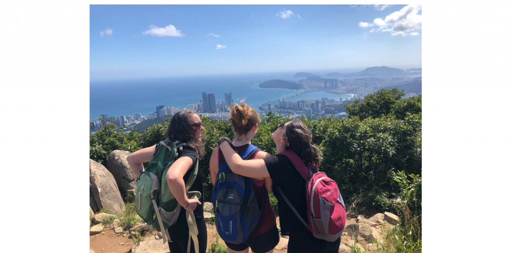 3 backpackers enjoying the view on top of a hill overlooking Busan beach highlighting life in korea