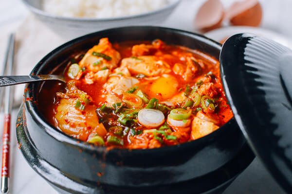 a black bowl of spicy Korean sundubu jjigae