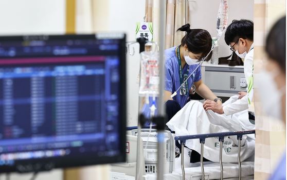 Two doctors helping a patient in the ER in Korea