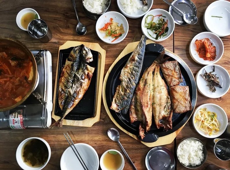 Assorted fish, kimchi stew, and side dishes at a traditional restaurant in Korea