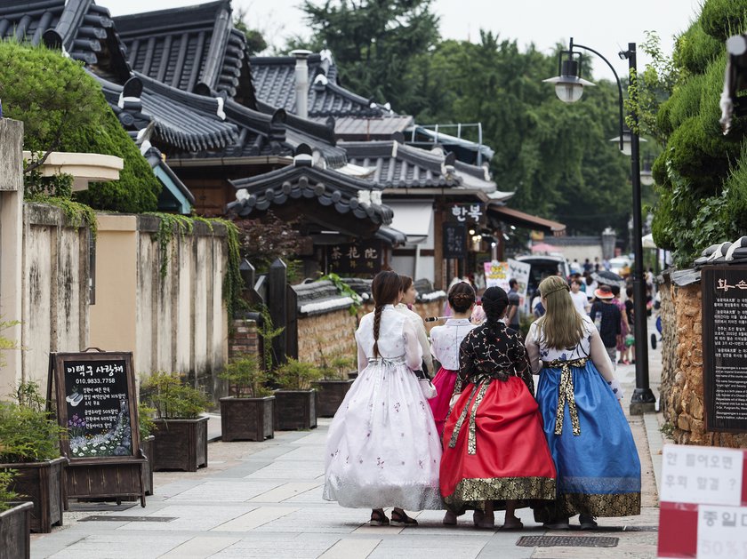 Women wearing traditional Korean hanboks walk the streets of Jeonju South Korea
