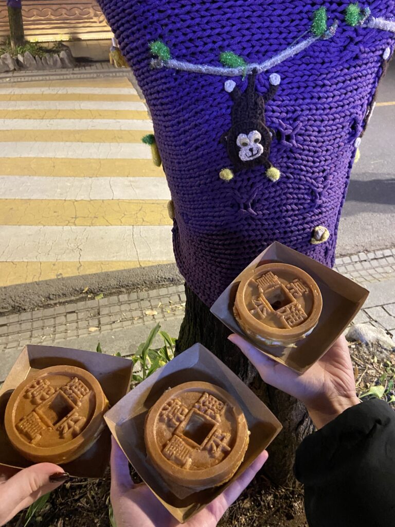 Traditional Jeonju-style coinbread being held out by 3 people.