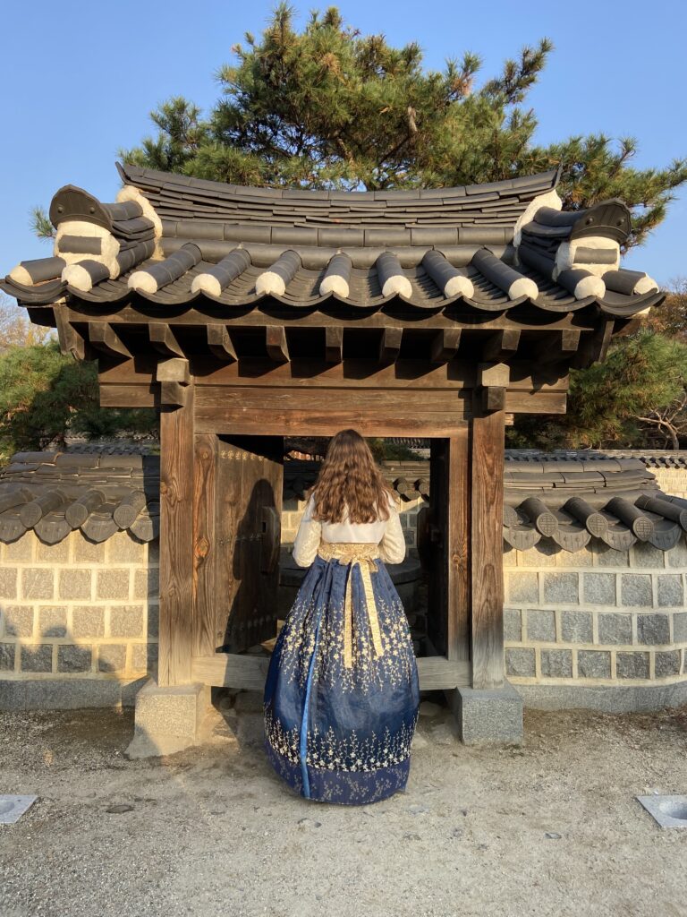 Woman in a traditional Korean Hanbok at the gate of a the Jeonju Hanok village.